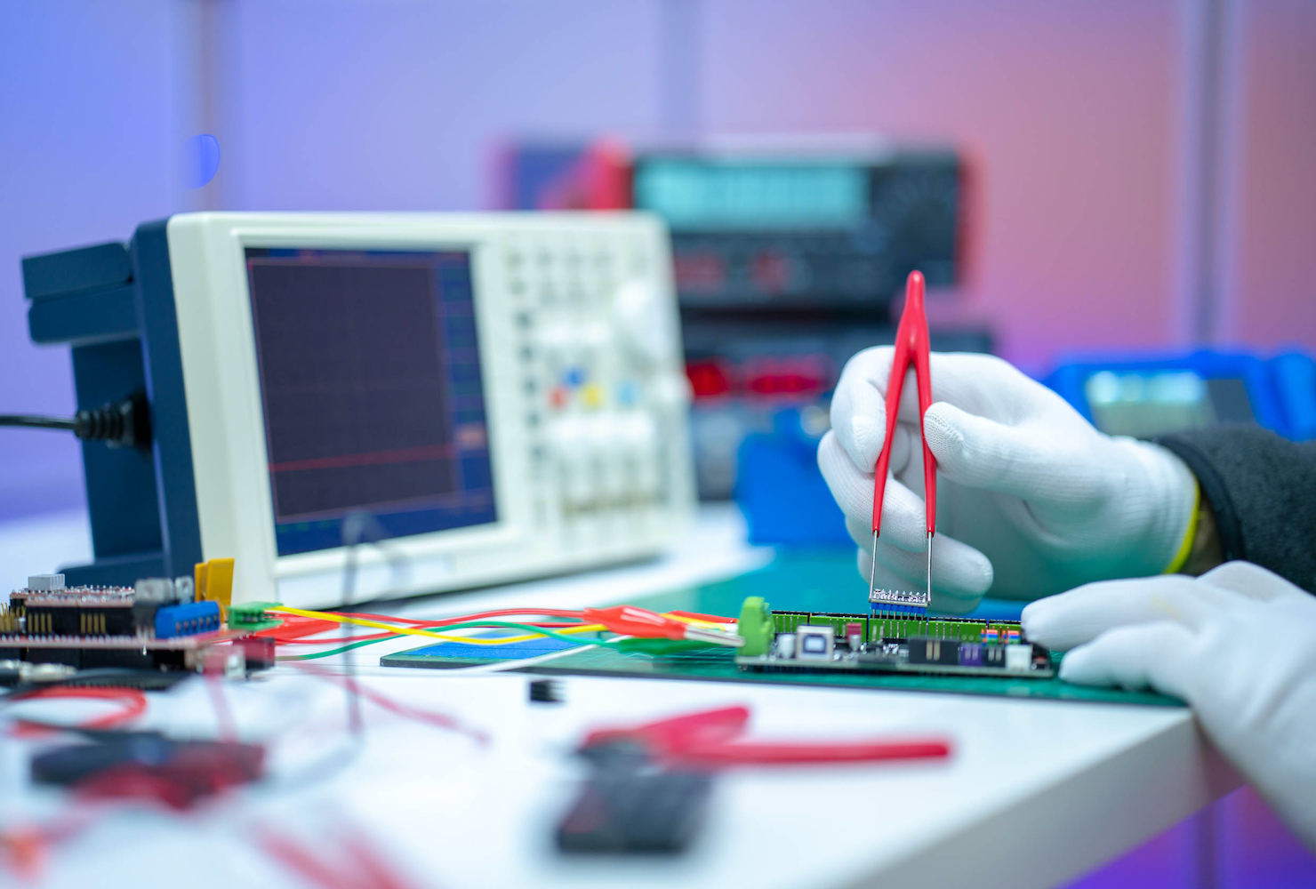 In un laboratorio, un ricercatore assembla una scheda elettronica.r